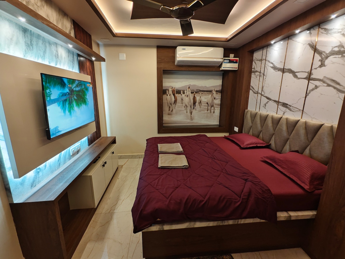 King-size bedroom at The Riansh Homestay, Puri, with ambient ceiling lighting and smart TV